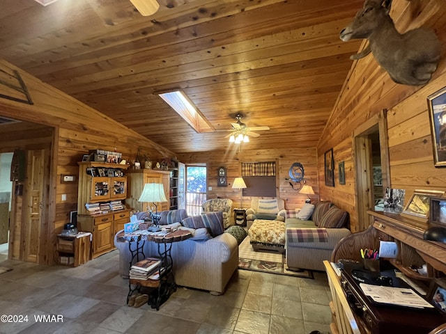 living area featuring vaulted ceiling with skylight, wood walls, and wooden ceiling