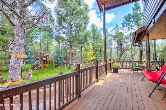 wooden deck featuring a lawn