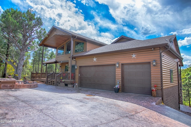 view of front of house with faux log siding, concrete driveway, roof with shingles, and an attached garage