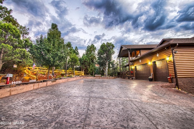 view of side of property featuring concrete driveway, log veneer siding, and an attached garage