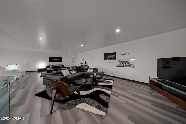 living room featuring baseboards, wood finished floors, and recessed lighting