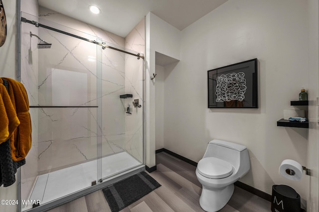 full bathroom featuring baseboards, toilet, and a marble finish shower