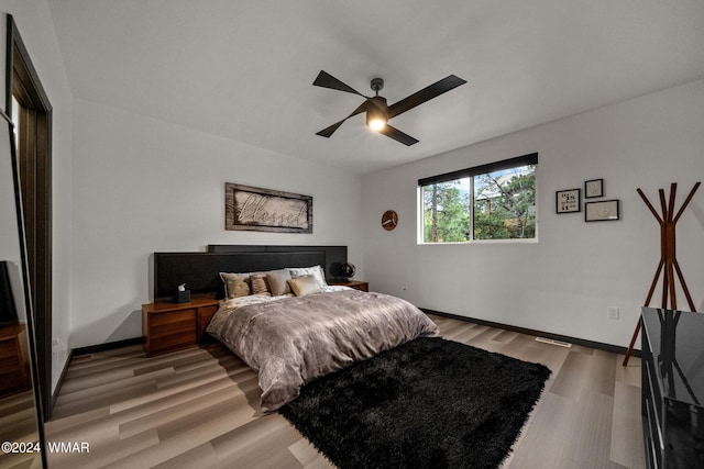 bedroom featuring light wood-type flooring, ceiling fan, and baseboards