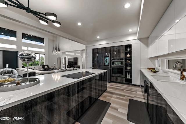 kitchen featuring light stone counters, white cabinetry, a sink, and modern cabinets