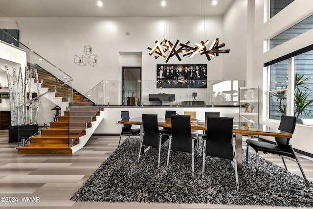 dining area with a high ceiling, stairway, and wood finished floors