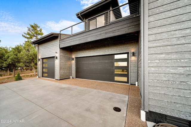 view of side of property with an attached garage and concrete driveway