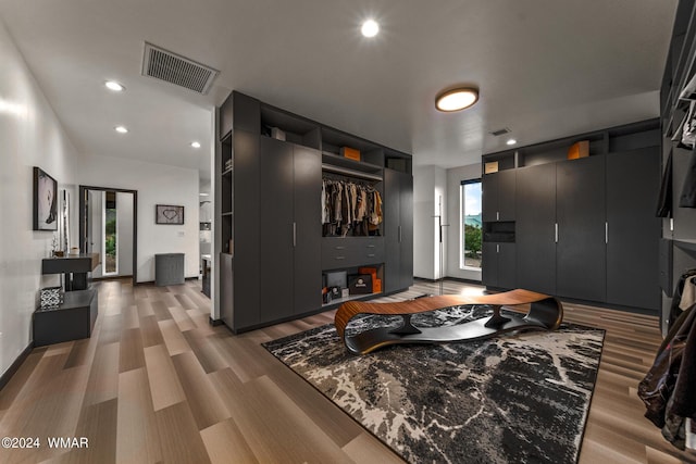 living room with recessed lighting, visible vents, and light wood finished floors