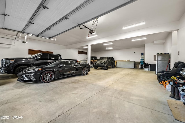 garage with a garage door opener and freestanding refrigerator