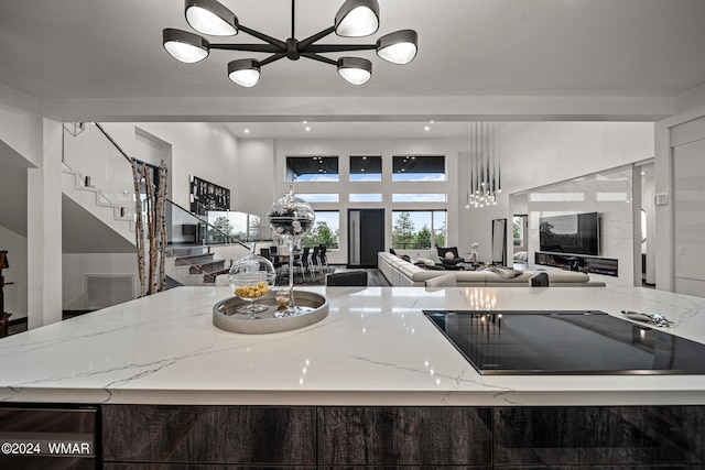 kitchen featuring visible vents, open floor plan, light stone counters, and recessed lighting