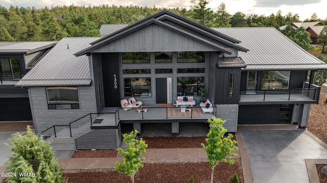 view of front of home featuring a garage, concrete driveway, and metal roof