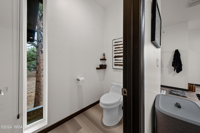 bathroom with toilet, visible vents, and baseboards