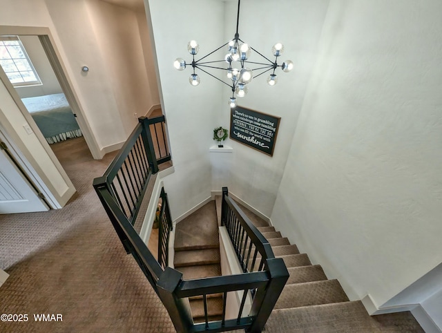 staircase featuring baseboards, carpet, and an inviting chandelier