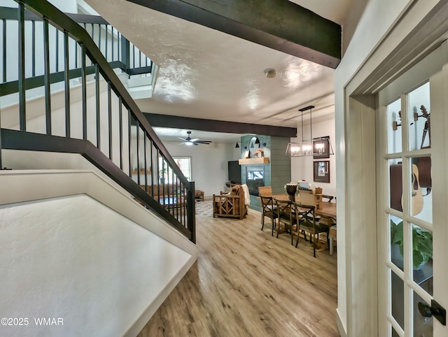 interior space featuring ceiling fan with notable chandelier and wood finished floors