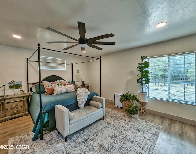 bedroom featuring a textured ceiling, ceiling fan, and wood finished floors