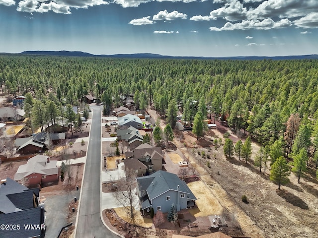 drone / aerial view with a wooded view