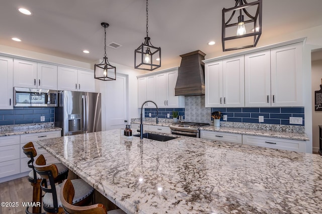 7758 James Pearce Way, Taylor, AZ 85939 - kitchen featuring custom range hood, appliances with stainless steel finishes, backsplash, a kitchen bar, and recessed lighting