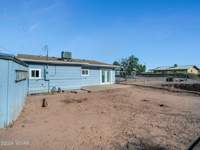 back of property with fence and central AC