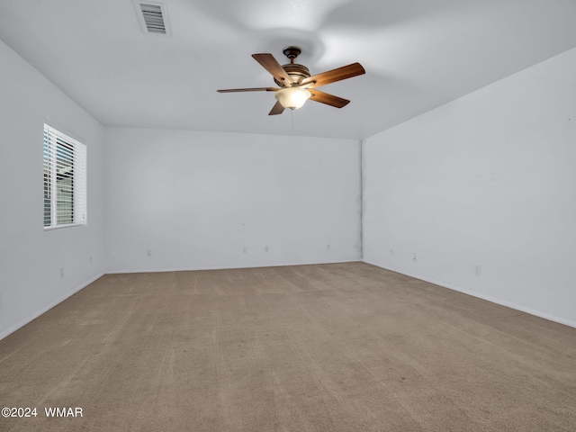 empty room with ceiling fan, visible vents, and light colored carpet