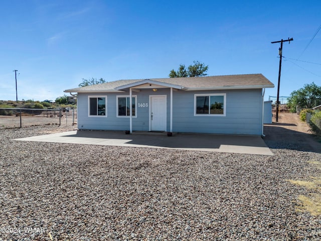 view of front of property featuring a patio and fence