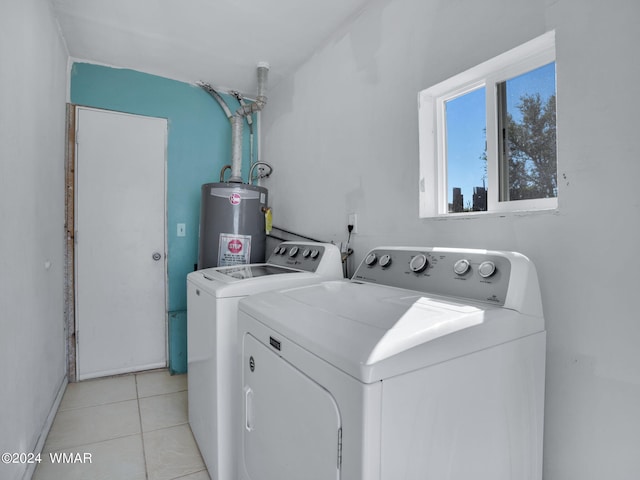 laundry room with laundry area, water heater, washing machine and clothes dryer, and light tile patterned floors