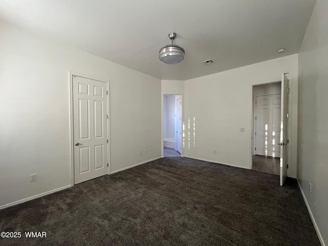 420 Washington St, Snowflake, AZ 85937 - unfurnished bedroom featuring dark carpet, baseboards, and visible vents