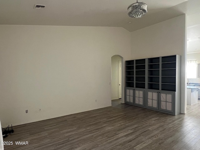 420 Washington St, Snowflake, AZ 85937 - empty room featuring arched walkways, lofted ceiling, visible vents, and dark wood-style floors