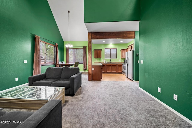 242 E Pinecrest Dr, Pinetop, AZ 85935 - living room featuring a textured wall, light carpet, baseboards, a chandelier, and high vaulted ceiling