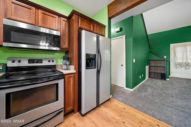 242 E Pinecrest Dr, Pinetop, AZ 85935 - kitchen featuring stainless steel appliances, beam ceiling, brown cabinets, light wood-type flooring, and light countertops