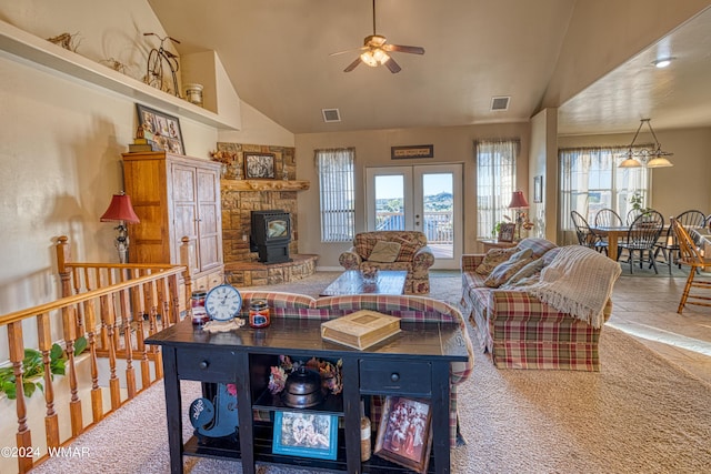 living room with a wood stove, french doors, high vaulted ceiling, and visible vents