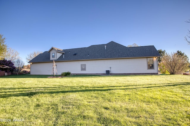 view of home's exterior with a shingled roof, a lawn, and central air condition unit