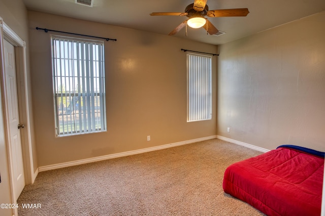 carpeted bedroom with a ceiling fan, visible vents, and baseboards