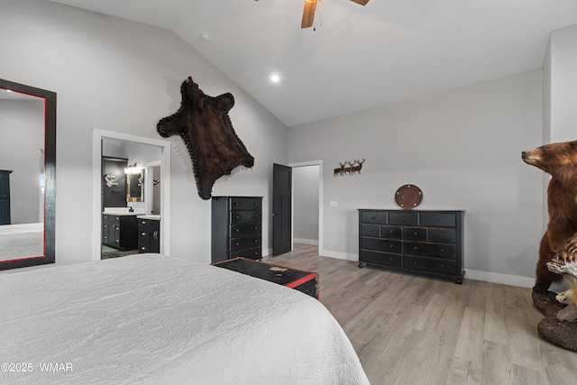 bedroom with high vaulted ceiling, wood finished floors, baseboards, ensuite bathroom, and ceiling fan
