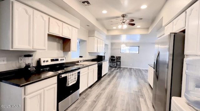 kitchen featuring stainless steel appliances, a sink, visible vents, white cabinetry, and dark countertops