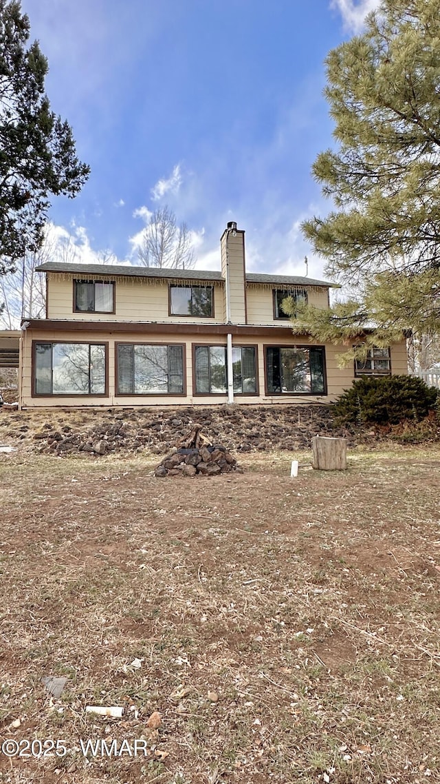 back of property with a chimney