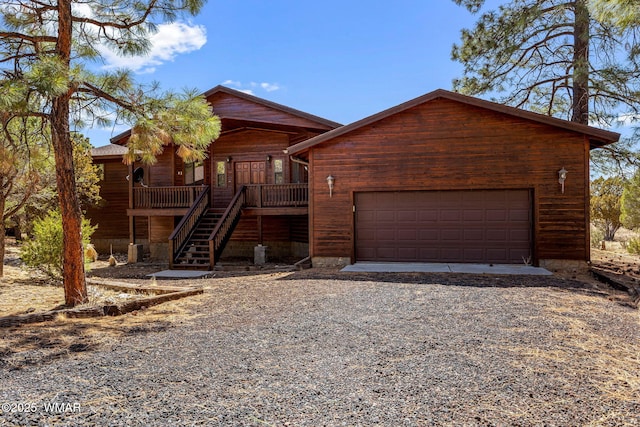 rustic home with gravel driveway, stairway, and an attached garage