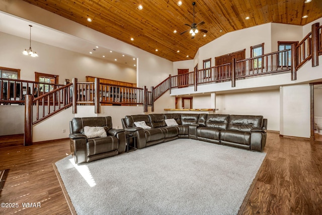 living area featuring wood ceiling, high vaulted ceiling, and stairs