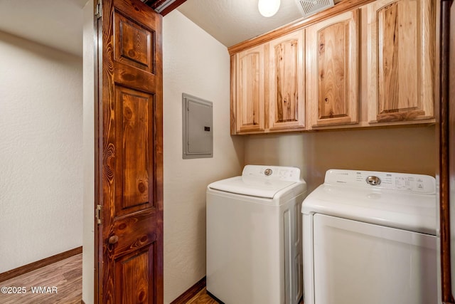 laundry area with separate washer and dryer, visible vents, electric panel, baseboards, and cabinet space