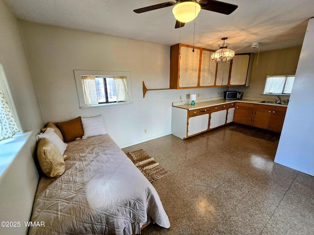kitchen with healthy amount of natural light, light countertops, ceiling fan, and granite tiled floors