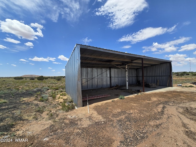 view of pole building featuring a detached carport and a rural view