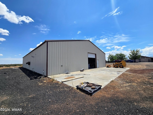 view of outdoor structure featuring an outbuilding and concrete driveway