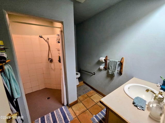full bathroom with a stall shower, toilet, vanity, and tile patterned floors