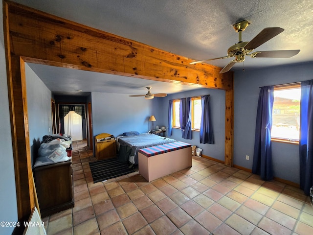 bedroom with a ceiling fan, a textured ceiling, baseboards, and light tile patterned floors