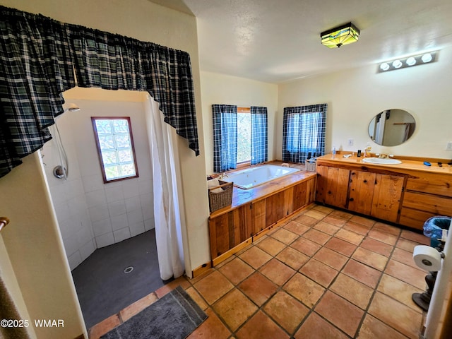 full bathroom featuring a garden tub, vanity, a tile shower, and tile patterned floors