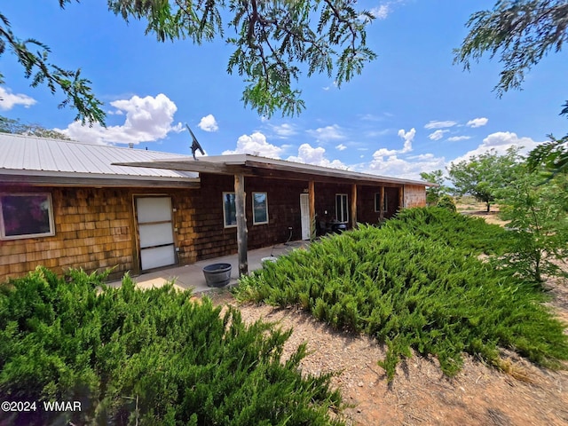 back of house featuring metal roof and a patio