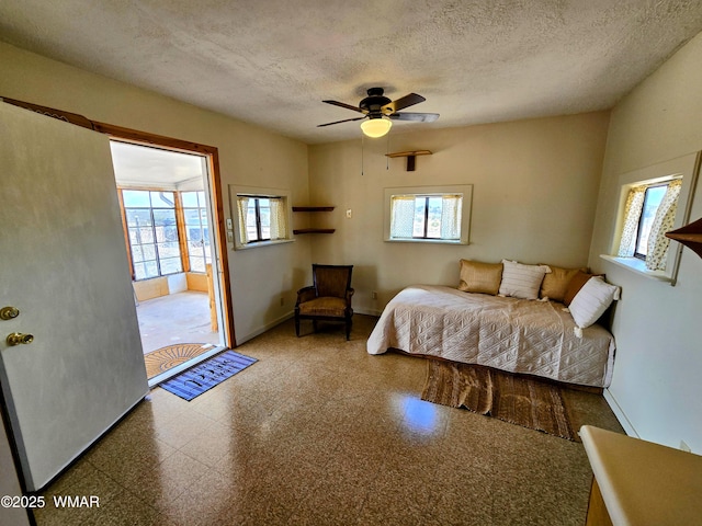 bedroom featuring multiple windows, a textured ceiling, baseboards, and ceiling fan