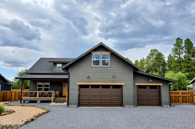 view of front of home featuring driveway, a shingled roof, an attached garage, and fence