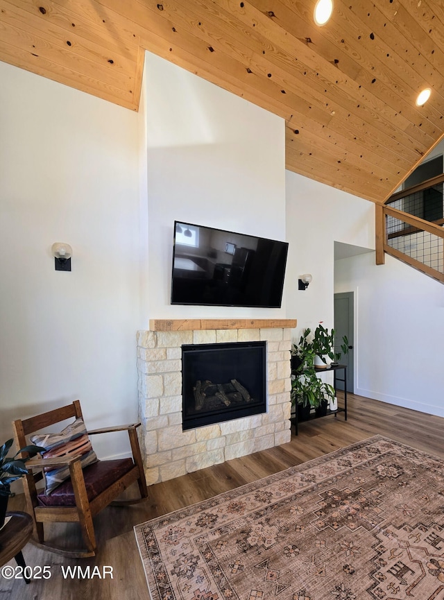 living area with a stone fireplace, wooden ceiling, high vaulted ceiling, and wood finished floors