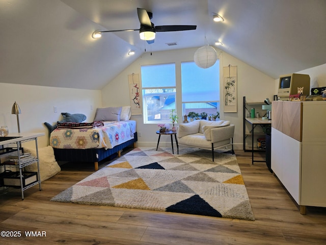 bedroom featuring visible vents, baseboards, ceiling fan, vaulted ceiling, and wood finished floors