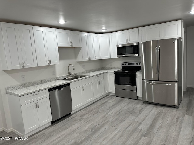 195 S 4th St, Snowflake, AZ 85937 - kitchen with white cabinets, stainless steel appliances, light wood-style flooring, and a sink