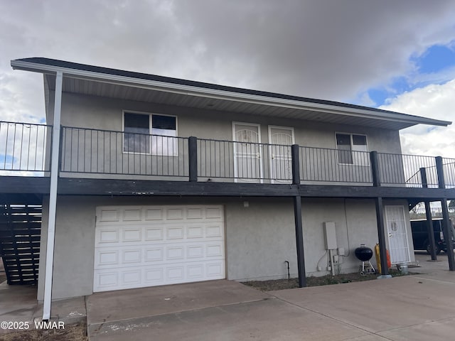 195 S 4th St, Snowflake, AZ 85937 - rear view of house featuring concrete driveway, an attached garage, stucco siding, and a balcony